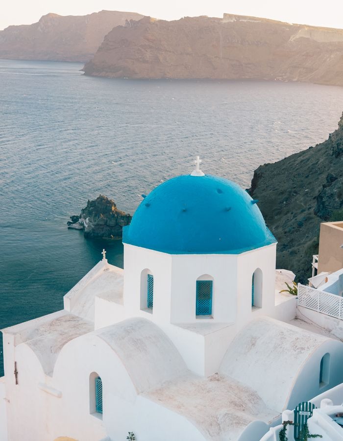 Casas blancas y cúpulas azules sobre el mar Egeo en Santorini, Grecia